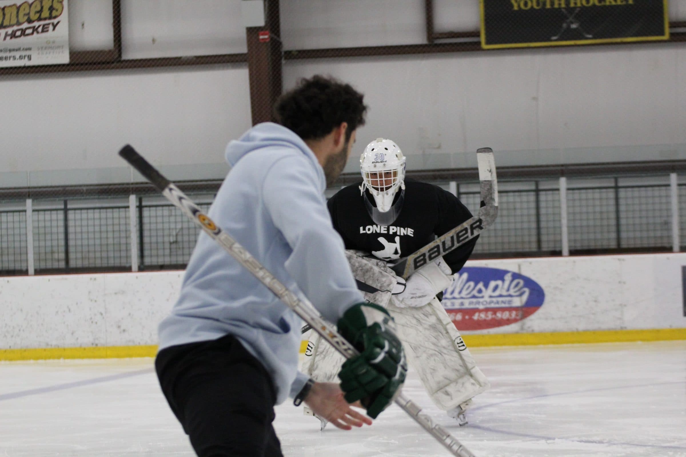 Shea Spanier coaching a goalie on the ice